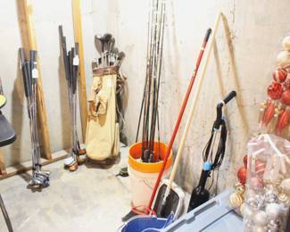 Vintage golf clubs, regular golf clubs, fishing poles.