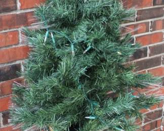 Lighted Christmas tree on side table.