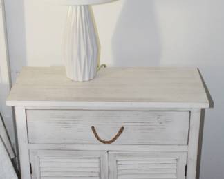 White distressed nightstand and lamp.