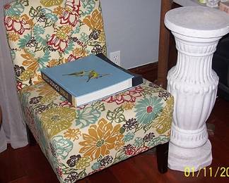 Upholstered chair, bird book, pedestal