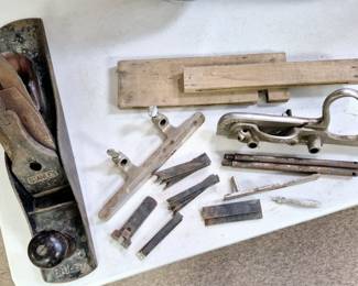 Table full of vintage and modern hand tools. "Stanley Bailey # 5" and "Stanley # 50" hand planes