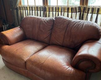 2 Cushion Leather Sofa with Rolled arms and nail head trim.