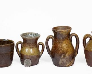 Four Small Pieces of Salt-Glazed Stoneware, Middle TN origin, late 19th or early 20th century, two open-handled vases, a mug, and an ovoid jug, each dipped in brown slip and covered in a salt glaze. Provenance: Smaller vase and mug found in Crossville, TN in 1976. Note on sticker on bottom of mug notes, "Man said it is a (George) Dunn." Two vases in excellent condition, the larger with some small bits of in-the-firing clay residue adhered to surface. Mug with a chip to interior of rim and some light surface wear. Jug with a minor spout nick and base wear. H (of tallest) 4 5/8". ($400-$600)
