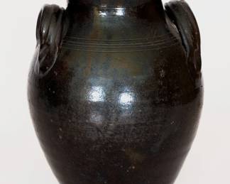Scarce Glazed Redware Jar, TN or NC origin, early to mid 19th century, ovoid jar with footed base, tooled shoulder, tall collar with flattened rim, and ribbed open-strap handles, the surface covered in a black lead-and-manganese glaze. This beautifully-potted jar is described in Wahler's notes as "definitely related to TN pots, but possibly NC." Provenance: Case Antiques, Inc. Auctions & Appraisals, Knoxville, TN. Very nice condition with a few base chips, a shallow 3/4" chip to one handle, minor chipping to interior of rim, and areas of surface wear to jar, primarily at midsection. H 12 5/8". ($1000-$1500)
