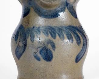Rare Squat-Form Stoneware Pitcher with Cobalt Floral Decoration, attributed to the Decker Pottery, Washington County, TN, circa 1872-1910, wide-bodied, ovoid pitcher with flared rim, brush-decorated around the body with a swag-and-hanging-flower motif and around the shoulder with a series of stylized drapes. Cobalt highlights to handle terminals. Exceptional form with strong decoration inspired by the Parr family of Baltimore and Richmond. Exhibited: Tennessee Turned, Earthenware and Stoneware Made in East Tennessee 1800-1900, Museum of East Tennessee History, May 16-October 30, 2011. Two in-the-firing surface flakes to front. Light surface wear to midsection. A 1 1/4" chip and minor chip to proper left side of rim. A shallow 3/4" chip to interior of spout. A minor, very shallow 1 1/2" in-the-firing contact mark to rim. Two smooth, minor chips to bottom edge, probably in-the-making. H 7 1/2". ($2000-$3000)
