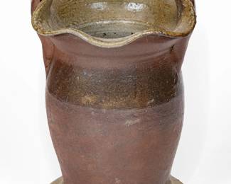 Salt-Glazed Stoneware Vase, Middle TN origin, late 19th or early 20th century, ovoid form with pronounced foot, horizontal strap handle, and crimped rim, the surface dipped in reddish-brown slip and covered in a salt glaze. A professionally-restored 1 3/4" x 5/8" rim chip. An additional small restored rim chip. A small in-the-firing surface flake to handle. A minor chip to underside along bottom edge and two very minor, possibly in-the-making base nicks. H 9 1/4". ($150-$300)
