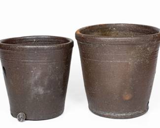 Two Salt-Glazed Stoneware Flowerpots, attributed to the Decker Pottery, Washington County, TN, circa 1872-1910, both of flaring form with tooled shoulders, semi-rounded rims, and original drain holes in underside. Provenance: Previously purchased from Knox Flea Market from Gladis Landreath, a nurse for one of the Deckers. Larger with wear to rim and two hairlines from rim. Smaller with two hairlines from rim. Both slightly out-of-round with salt drips. H (of larger) 8 3/4". ($100-$200)
