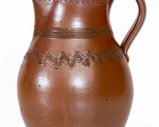 Albany-Slip-Glazed Stoneware Pitcher, TN origin, late 19th century, thin-walled, ovoid pitcher with footed base, flared collar, and incised band at base of collar, featuring combed wavy incising to the shoulder and midsection. Surface covered in a chocolate-brown Albany slip glaze. Excellent, essentially as-made condition. One spout chip. Two minor rim chips. H 9". ($150-$250)
