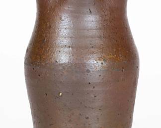 Rare Small Salt-Glazed Stoneware Pitcher, Stamped "T. B L," Thomas B. Love Pottery, McMinn County, TN, circa 1830-1860, semi-ovoid pitcher with flared collar and heavily-ribbed handle, impressed with Thomas Boston Love initialed maker's mark at base on reverse. Salt-glazed surface with green salt drip to handle. Exhibited: Tennessee Turned, Earthenware and Stoneware Made in East Tennessee 1800-1900, Museum of East Tennessee History, May 16-October 30, 2011. Literature: For a jar and jug by this maker, see Wahler, Tennessee Turned, Earthenware and Stoneware Made in East Tennessee 1800-1900, Part One, p. 123, figs. 125 and 126, and p. 212, figs. 125 and 126. Provenance: Purchased from Mary Jo Case. Very nice conditon. Two small in-the-firing chips to underside along bottom edge. Light wear around midsection. An in-the-firing stone ping to proper right side of pitcher. Spout with a small chip and wear. Rim with a minor nick and minor wear. H 7". ($1500-$2500)
