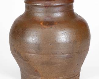 Rare and Fine Small-Sized Stoneware Jar with Lid, Stamped "SMITH.IR," Samuel Smith, Knox County, TN, circa 1820-1830, globular jar with heavily-tooled base and narrow, semi-rounded mouth, potted with an inner rim for lid. Salt-glazed exterior and Albany-slip-glazed interior. Impressed with Samuel Smith maker's mark on underside. Includes original salt-glazed stoneware lid. A particularly early example of Tennessee stoneware featuring appealing form and size and remarkably retaining its original cover. Exhibited: Tennessee Turned, Earthenware and Stoneware Made in East Tennessee 1800-1900, Museum of East Tennessee History, May 16-October 30, 2011. Literature: Illustrated in Wahler, Tennessee Turned, Earthenware and Stoneware Made in East Tennessee 1800-1900, Part One, p. 109, fig. 118, p. 211. Very nice condition with a series of small rim chips. Lid in excellent condition with two minor chips to underside. H (including lid) 7 1/4". ($1500-$2500)
