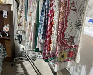 Vintage linens including several state tablecloths. Also doilies and pillow cases