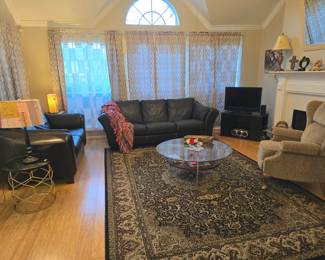 Leather couch and loveseat, neutral-colored recliner, beautiful area rugs, coffee tables and occasional tables, and a large variety of lamps, too!