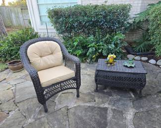 Wicker patio chair and storage table, assorted planters, and yard art