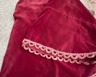 Plush red velvet round tablecloth with ornate trim 