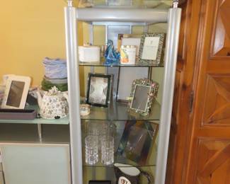 Glass and brushed nickel shelves. lenox frames, lead crystal water glasses and salad bowl. Photo frames and candles.
