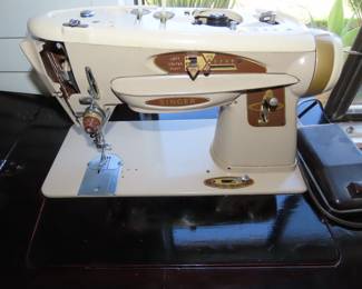 Vintage Singer sewing machine in cabinet.