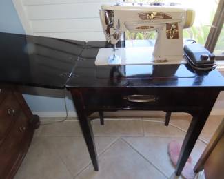 Vintage Singer sewing machine in cabinet.
