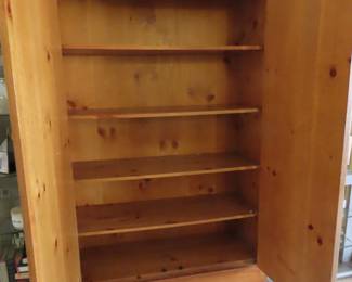 Tall solid two door wood clothing/storage cupboard/armoire with multiple shelves.
