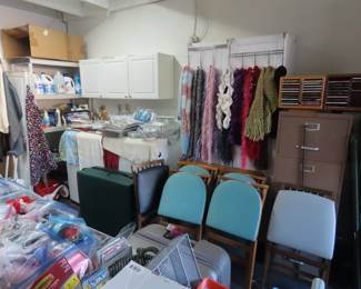 Scarves, games table and folding chairs, bags of ribbon spools.