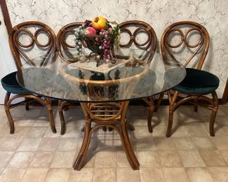 Bamboo base table with round glass top and four bamboo chairs.