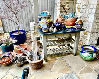 OUTDOOR GRANITE TOP TABLE FULL OF TALAVERA, POTTERY.