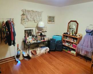 This room has Vintage to newer clothing, Hats, Vintage Salon Hair Dryer, Cosmetic Items, Personal Care items, Suitcases, Mirrors, Scarves, Lamps, Chair, Bookshelf, & More