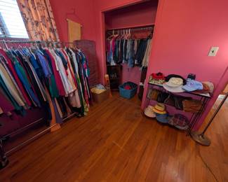 This room has a full closet full of pants and both of these racks full of clothing