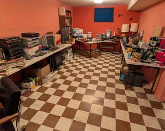 room full of electronics, some books, computer joysticks and more