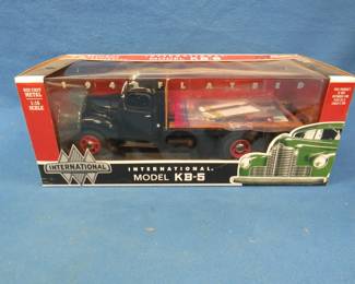 Lot 19. Ertl Toy Trucker 1948 International Flatbed KB-5 in the original box. 1:16 scale die-cast truck, chains, planks, and a chain binder.