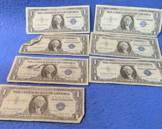Lot 349. Seven $1.00 silver certificates: - (1) 1935 D - (1) 1957 - (3) 1957 A - (2) 1957 B"
