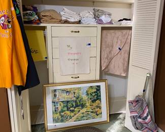 Aprons (2) on left, yellow pillow case set, queen & full sheets, sets, & additional pillow cases, lovely large framed picture, small rug, backpack on right door.