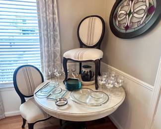 Antique claw foot pedestal table and two Pottery Barn chairs.