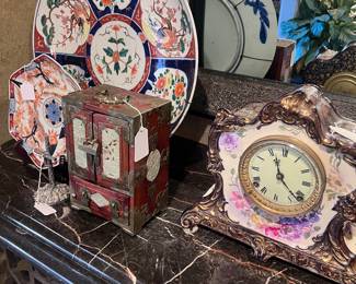 Left to right: Giant antique plate, antique Imari plate, antique wood jewelry box with jade, Royal Bonn Ansonia “La Drome” mantle clock