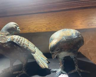 This pair of 20th-century cast metal Mourning Doves features one bird standing upright and the other gracefully bent over, designed to peer over the edge of a bookshelf or fireplace mantle. The doves are finished with a patina giving the look of aged bronze. Mourning doves symbolize peace, love, and devotion.