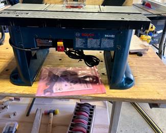 #108 - $160 - Bosch router table # RA1181 with Bosch router attached #1617EVS with wrenches, inserts and feed
