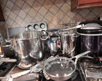 Fantastic Selection of Calphalon Kitchenware including a 2.5 Quart Pot with Lid, a 6 Quart pot with lid, and an 8" Frying Pan with lid, a Cuisinart Electric Knife with Two Sets of Blades, an ArcoSteel Stainless Steel Stockpot and a Stainless Asparagus Pot with Lid and Basket. 