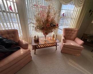 . . . retro coffee table, nice floral arrangement, and pink upholstered chair and love seat/couch