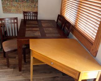 A dining room table with four chairs and a corner desk.