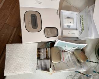 Phonak charger, Phonak ComPiolot,  Nano CIC rechargeable digital unit, and over 100 batteries.