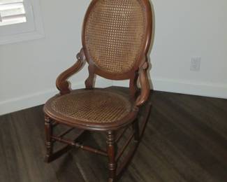 Antique walnut caned rocking chair.