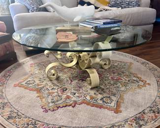 Glass top and metal scrolled coffee table and round rug