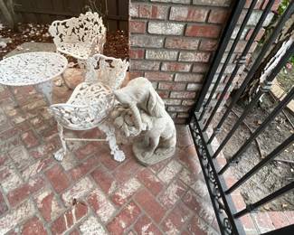 large concrete French style dog and a sweet wrought iron cafe set