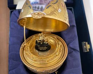 MAGNIFICENT \"PETER THE GREAT\" EGG . RECREATED BY FABERGE, THE ORIGINAL WAS MADE FOR EASTER 1885 WHEN CZAR ALEXANDER III GAVE TO HIS WIFE, CZARINA MARIA FEDOROVNA. A PRIZE EGG HAVING JEWEL STUDDED VIGNETTES OF ENAMEL PORTRAITS AND SCENES ON HEAVY EMBOSSING AND FLOWING RIBBON BANNERS OPENING TO REVEALING CZAR AND CZARINA ON HORSEBACK IN A CHAINED GALLERY VIGNETTE.SIGNED ON INTERIOR, "TATIANA FABERGE". WITH FABERGE GIFT BOX , IN EXCELLENT CONDITION. $3000