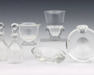 Six pieces of 20th century Steuben Crystal tableware.  Includes a pedestal vase, pedestal bowl, two decanters and two candy dishes.  Each signed "Steuben".  Some surface wear, one decanter stopper with chip.  Up to 7 1/2" high.  
