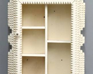 An early 20th century American Tramp Art wall cabinet.  Wooden multi-layered chip carved design with shaped crest over a long door with shelved interior and White painted finish.  Painted with some wear, lacks mirror, minor damage.  Approx. 16 1/2 x 6 1/2 x 27" high overall.