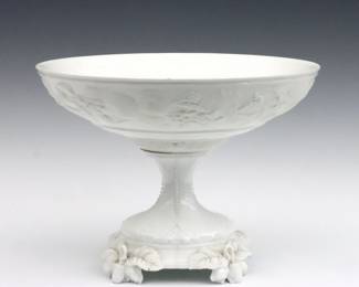 A turn of the century Jean Pouyat Limoges porcelain compote.  Molded fruit and floral decoration with bisque accents.  Printed "JP L" mark.  Chips to top of stem and feet.  9 3/4" diameter x 7 1/4" high.  