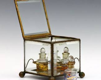 A 19th century French glass perfume casket.  Beveled glass hinged box with Bronze mounts and four interior bottles.  Replaced bottles contain thick amber fluid, panels with minor damage to corners, wear to patina.  5 x 4 3/4 x 4 1/2" high overall.