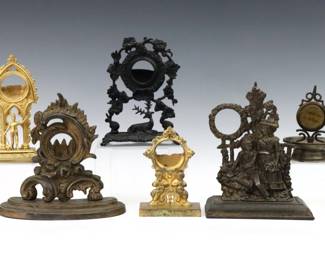 Six 19th to early 20th century cast metal pocket watch holders.  Various figural and floral designs.  Wear to patinas, Iron with oxidation.  Up to 8 1/2" high.  
