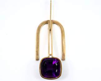 A 14k Gold and Amethyst Modernist pendant.  Features a square cut bezel set Amethyst stone approx. 14.25 x 14.25 mm, below an inverted U form pendant with articulated hanger.  Marked "14k" and "AK".  10.3 grams total.  Some surface wear.  1 1/2" high with hanger up.