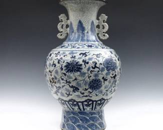 A Chinese Blue and White porcelain vase.  Large bulbous form with scrolled ears, floral decoration and crackle glaze.  Minor surface wear.  24" high.  
